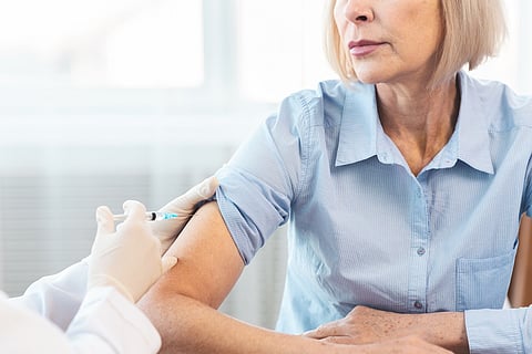 Closeup nurse doing vaccination to senior woman