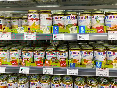 HiPP organic baby food jars neatly arranged on supermarket shelf, showcasing variety of flavors and vibrant packaging, ideal for parents seeking healthy options