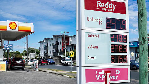 Gas station sign shows fuel prices at a Reddy Express Shell station near residential buildings in Australia during daytime