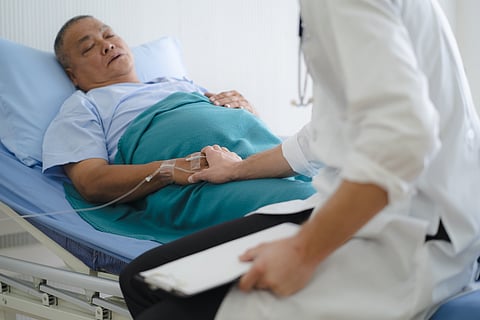 Doctor touching hands to encouragement mental of elderly patient after surgery at bed in hospital.