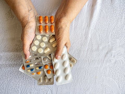 Senior Woman Hands Holding Multiple Medication Blister Packs at Home