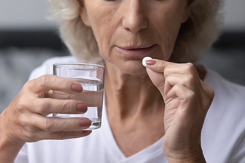 Middle-aged woman taking aspirin