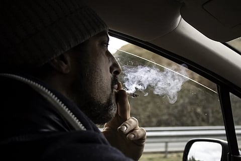 A man smoking pot in a car