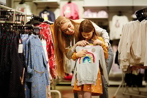 Madre e hija pequeña de compras