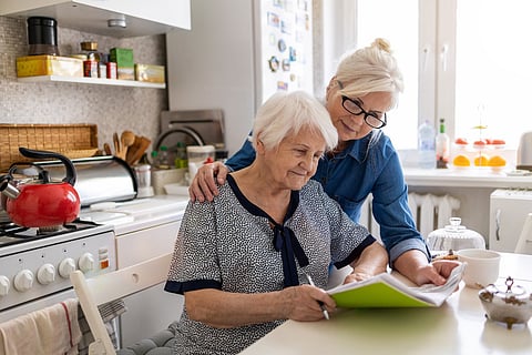 Madre anciana con su hija en la cocina, enfermedad de Alzheimer