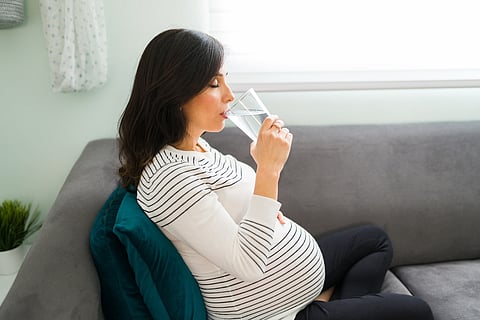 Mujer embarazada bebiendo agua