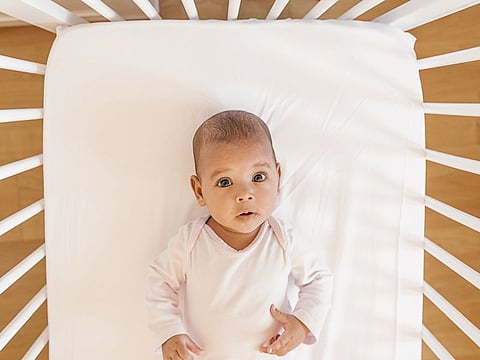 Cute Baby Girl Lying in the Crib. At home