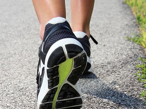 Close-up of Women's running shoes on a paved trail.