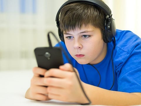 Teen using cell phone with a headphones