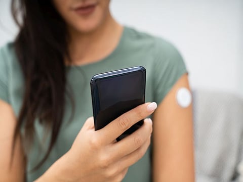 Woman Holding Smartphone In Hand With Bad Level Of Blood Sugar On The Screen
