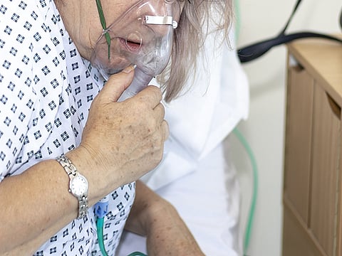 Woman in hospital with breathing difficulties using a resperation mask