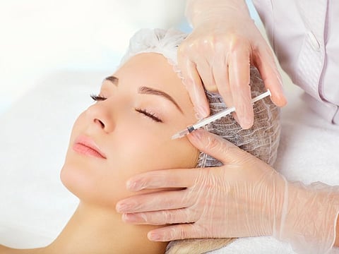 A woman receives an inejection on her face in the clinic.
