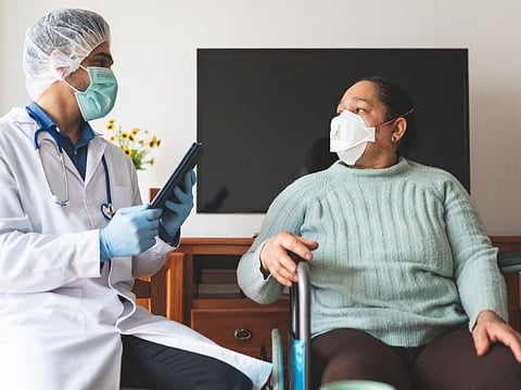 Latin American Doctor Checking Patient Infected of Covid-19 at Home. Doctor Checking Patient with Coronavirus. Doctor Doing Home Service. Healthcare Concept.