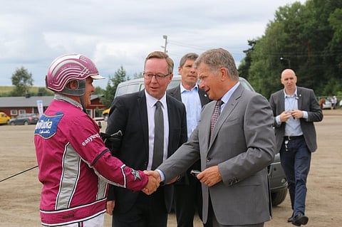 Suomen Hippoksen hallituksen puheenjohtaja Mika Lintilä isännöimässä tasavallan presidentti Sauli Niinistön ja ohjastaja Antti Teivaisen kohtaamista Turun kuninkuusraveissa 2016.
