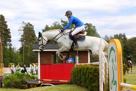 Derbykentän remontista vastannut Aki Ylänne katsoo ikkunasta kuinka Maija Yli-Huhtala ja Birchcape's Wonderland kiisivät Finnderbyn voittoon. Tässä orapihlajaesteellä.
