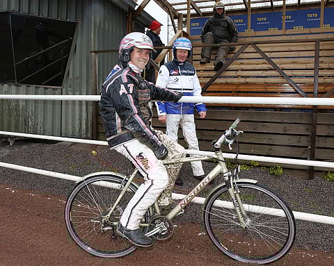 Antti Teivainen testasi uusitun kaviouran ensin hevosella, sitten polkupyörällä. "Hyvin sopi siihenkin hommaan", Teivainen huikkasi. Vermon valmentajat Pekka Korpi ja Pertti Puikkonen seurasivat performanssia kaarteesta. Kuva: Jarno Unkuri.