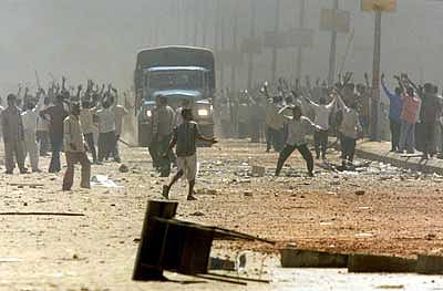 Rioters gathering around a truck vehicle on the street. 