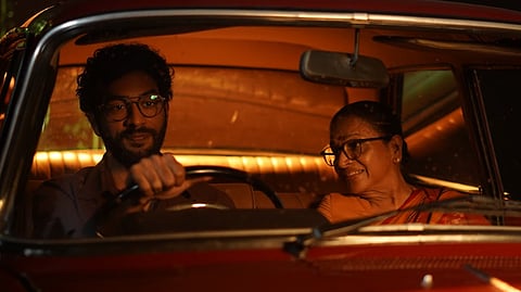 A still from the film 'Rani' showing the character of Richard de Zoysa driving a car with his mother, Manorani Saravanamuttu, in the passenger seat.