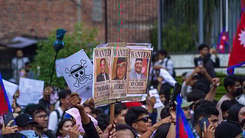 A placard with "Wanted" posters of major Nepali political leaders, including Prime Minister K P Sharma Oli, held aloft and amid Nepali national flags at a youth protest in Kathmandu
