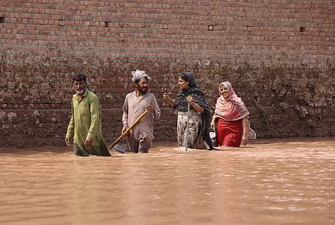 People wade through water in Pakistan’s Punjab province. By mid-September, at least 900 people had died and about four million were impacted by the floods that ravaged the country during the monsoon months.