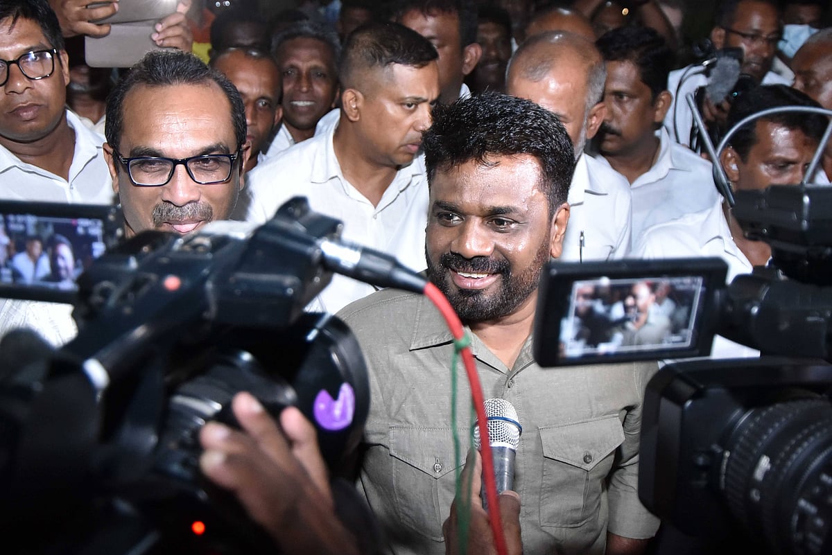 Anura Kumara Dissanayake wearing a grey shirt smiles at cameras outside his party office after winning Sri Lanka’s presidenti
