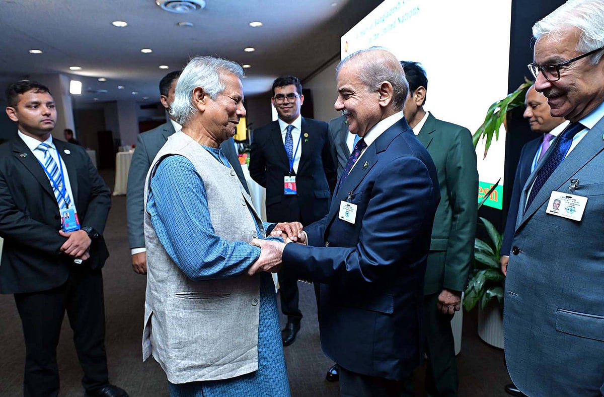 Muhammad Yunus (left) shakes hands with Shehbaz Sharif (right) amid a group of officials at a reception in New York in Septem