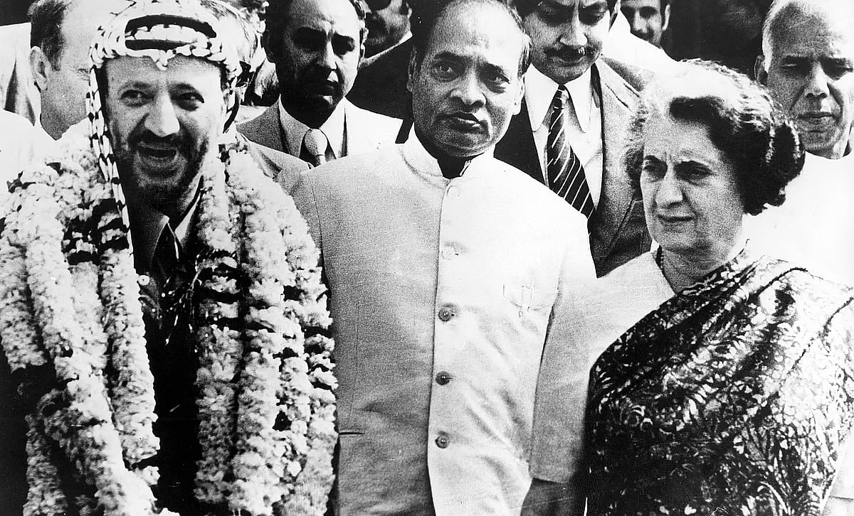 Yasser Arafat (left), the chairman of the Palestine Liberation Organisation, with Indira Gandhi (right) in Delhi in 1980. It is a black and white photo, with a crowd surrounding them.