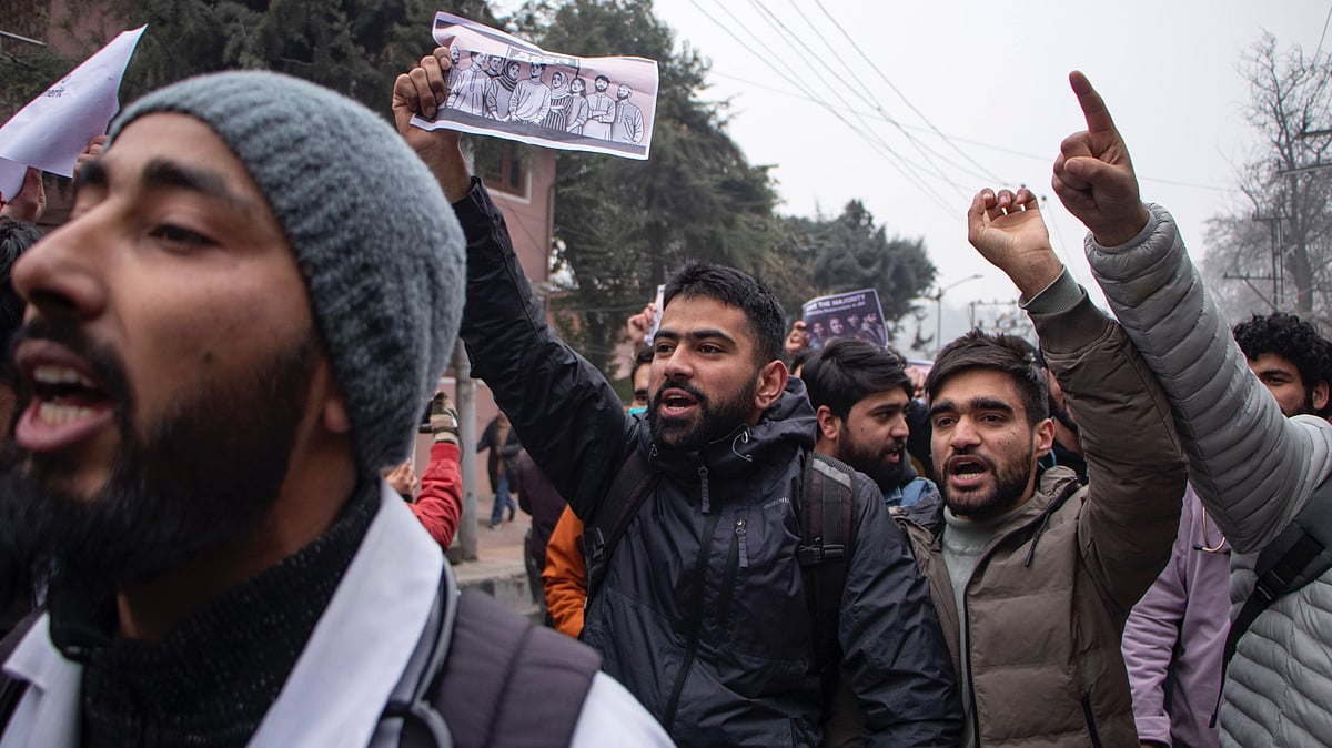 Young men dressed in warm clothed holding up banners and shouting slogans at a student demonstration in December 2024 against