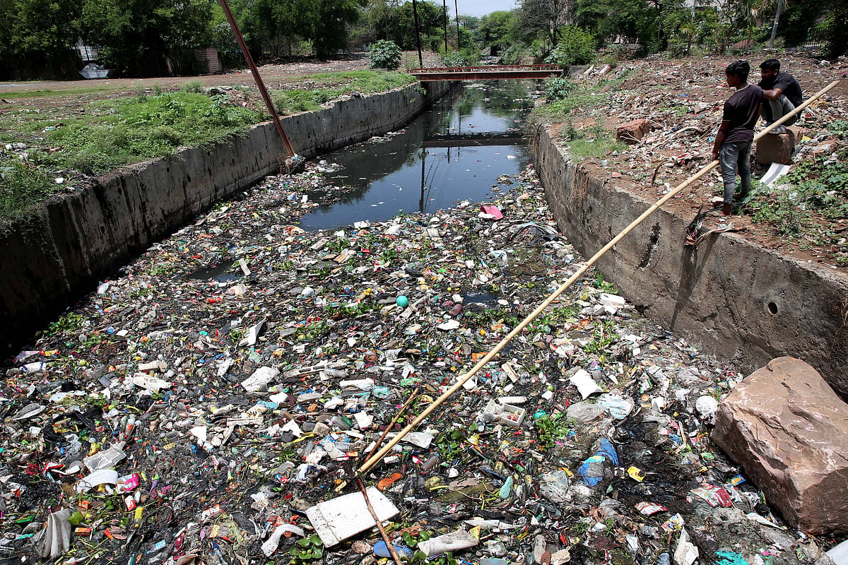 Sanitation workers clean up a large drain in Bhopal, India on World Environment Day.