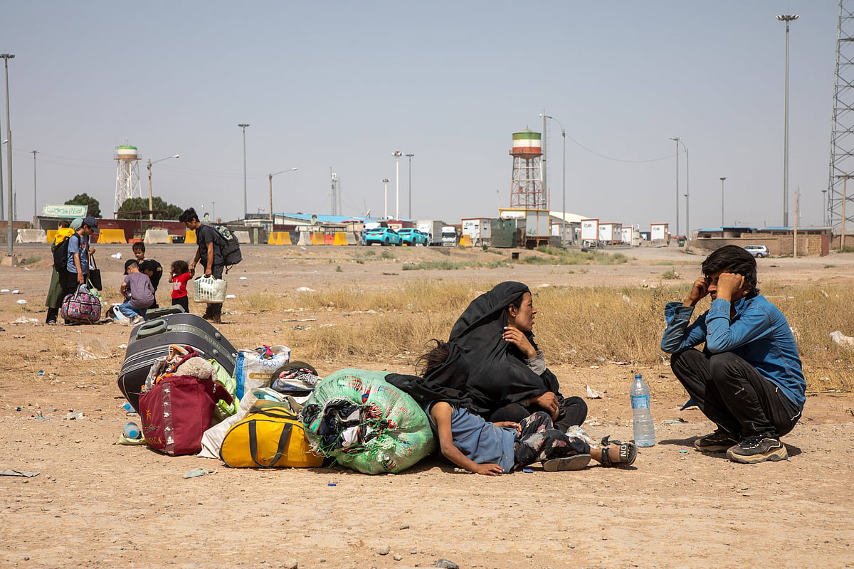 Afghan families rest on the ground after being deported from Iran at the Islam Qala crossing in Afghanistan.