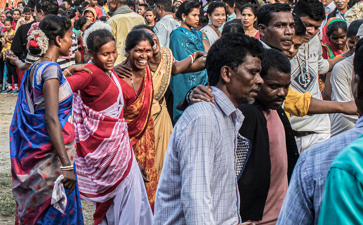 A lively crowd of people from the Oraon community in Purnea celebrates the spring festival of Sarhul. Men and women link arms