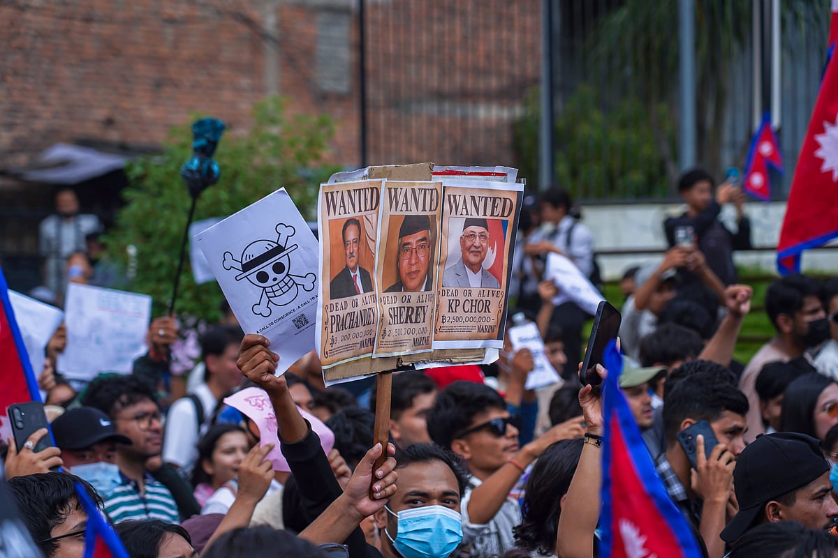A placard with "Wanted" posters of major Nepali political leaders, including Prime Minister K P Sharma Oli, held aloft and am
