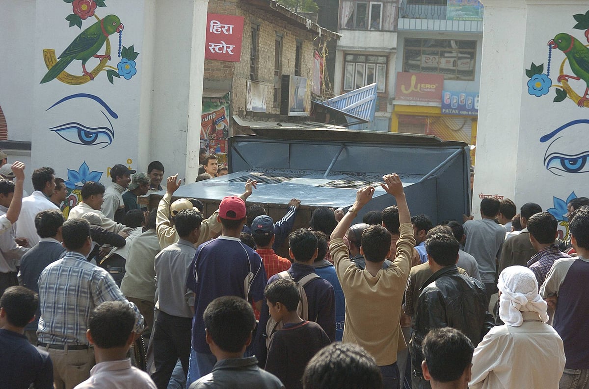 Nepal anti-monarchy protesters during Jana Andolan 2006 pushing over a tourist information centre in Boudha