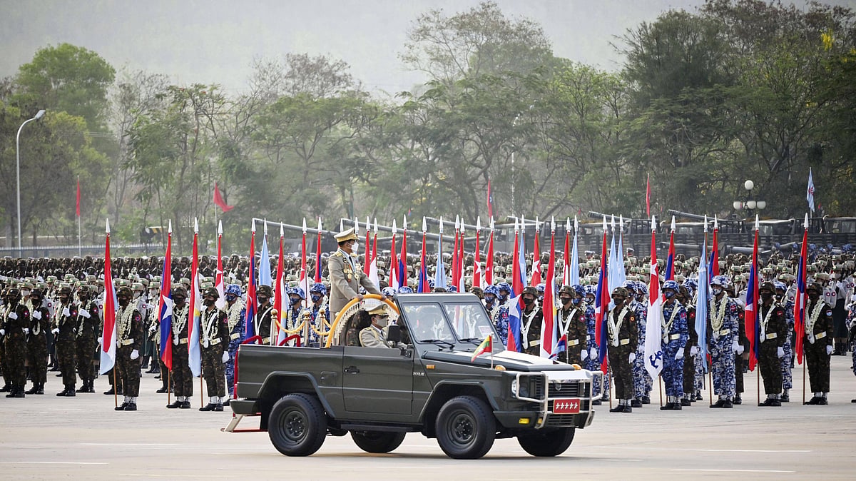 A military tank and rows of military on Armed Forces Day in Myanmar. They are all holding the Myanmar flag. 