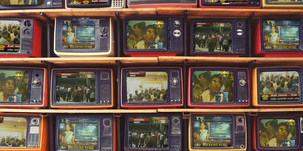 Photos of stacked vintage TV sets. On them is playing scenes from the former Sri Lankan labour minister storming the state owned TV station Rupavahini in 2007