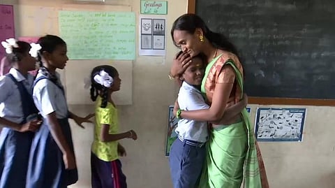 வகுப்பறைக்கு வரும் குழந்தைகளை நடனமாடியும் அரவணைத்தும் வரவேற்கும் அரசுப் பள்ளி ஆசிரியை