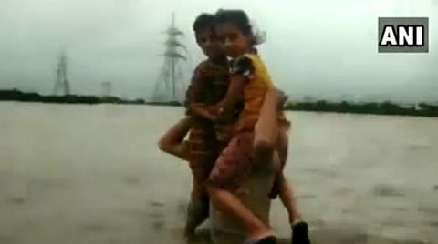 குஜராத் வெள்ளத்தில் சிக்கிய சிறுமிகள்: மார்பளவு தண்ணீரில் 1.5 கிலோ மீட்டர் தூரம் தோளில் சுமந்து காப்பாற்றிய போலீஸ்-வீடியோ