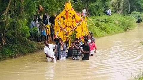 வாய்க்கால் வழியாக கொண்டுச் செல்லப்படும் உடல்