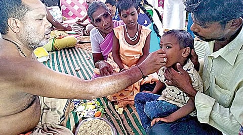 விஜயதசமியை முன்னிட்டு திருவாரூர் மாவட்டம் கூத்தனூரில் உள்ள சரஸ்வதி அம்மன் கோயிலில் நேற்று நடைபெற்ற வித்யாரம்பம் நிகழ்ச்சியில், நெல்மணிகளில் அகரம் எழுதப் பழக்கியதுடன், பேச்சு சிறந்து விளங்க ஒரு குழந்தையின் நாவில் நெல்மணியால் எழுதுகிறார் கோயில் குருக்கள்.