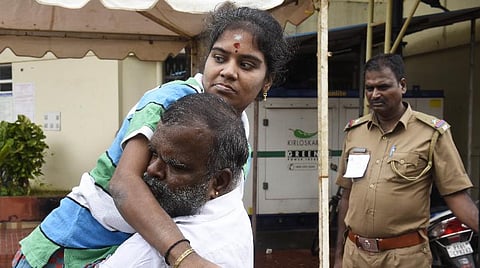 மாற்றுத்திறனாளி ஓருவரை வாக்களிக்க துாக்கி வரும் தந்தை.