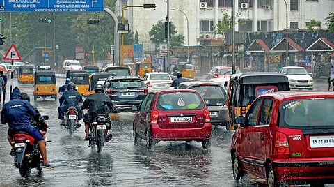 சென்னை அண்ணா சாலையில் மழையில் நனைந்தபடி செல்லும் வாகனங்கள்.