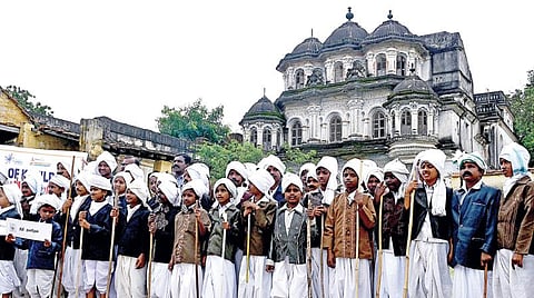 மகாகவி பாரதியின் 138-வது பிறந்தநாளை முன்னிட்டு தூத்துக்குடி மாவட்டம் எட்டயபுரத்தில் உள்ள அரண்மனை முன் பாரதியார் வேடத்தில் அணிவகுத்து நின்ற மாணவ - மாணவியர். படம்: என்.ராஜேஷ்