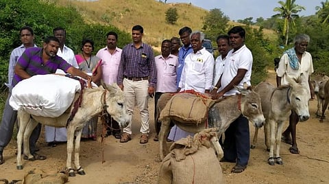 கழுதைகள் மூலம் கொண்டு செல்லப்பட்ட பொங்கல் பரிசுத் தொகுப்புடன் அதிகாரிகள்.
