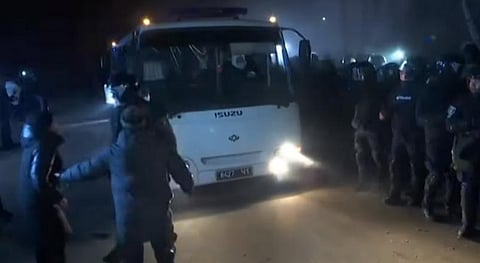 நோவி சன்ஷாரி நகருக்கு சீனாவிலிருந்து வெளியேற்றப்பட்டவர்களை ஏற்றி வரும் பேருந்துக்குப் பாதுகாப்பு அளிக்கும் தேசியப் பாதுகாப்புப் படையினர்.