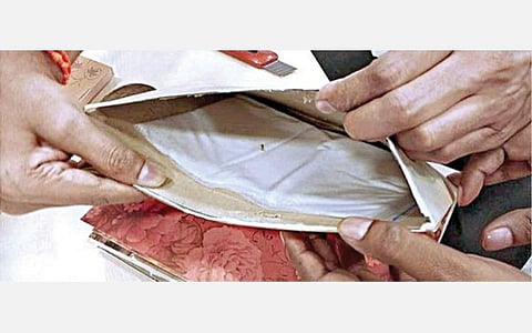 திருமண அழைப்பிதழ் உள்ளே மறைத்து வைக்கப்பட்டிருந்த போதைப் பொருள்.﻿﻿﻿﻿﻿﻿﻿