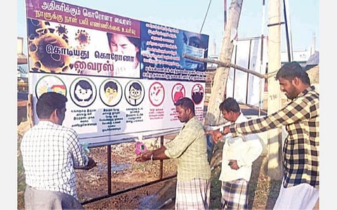 தஞ்சாவூர் மாவட்டம் பேராவூரணி அருகே செந்தலைவயல் ஊராட்சி பேருந்து நிறுத்தத்தில் அமைக்கப்பட்டுள்ள கோவிட்-19 வைரஸ் விழிப்புணர்வு பதாகை அருகில் உள்ள குழாயில் சோப்பு போட்டு கைகளைக் கழுவும் பொதுமக்கள்.