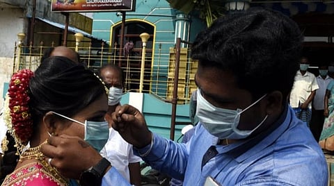 மணமகளுக்கு முகக்கவசம் அணிவிக்கும் மாப்பிள்ளை