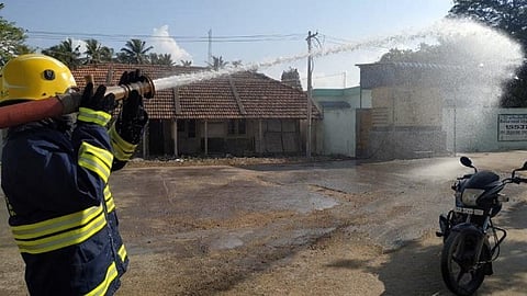 ராமேசுவரம் அரசு மருத்துவமனை வளாகத்தில் வெள்ளிக்கிழமை தீயணைப்புத்துறை வீரர் கிருமி நாசினி தெளிக்கிறார்.