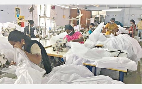 கரோனா வைரஸ் தடுப்புக்கான கவச ஆடைகளைத் தயாரிக்கும் தொழிலாளர்கள்.