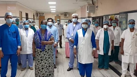 டிஸ்சார்ஜ் செய்யப்பட்ட மூதாட்டியுடன் மருத்துவர்கள்.